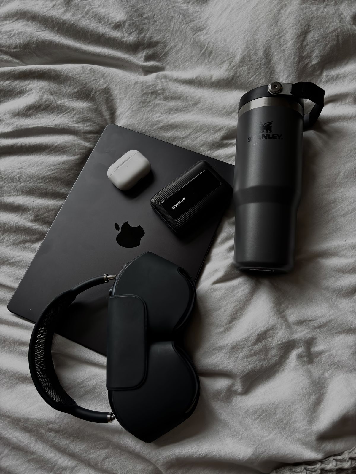 Dark flatlay of tech and self-care essentials